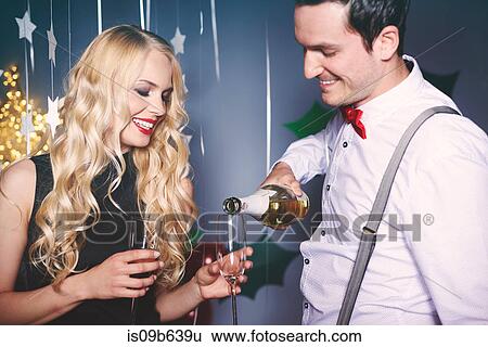 Man and woman at party, man pouring champagne into woman's glass View Large Photo Image Stock Photograph - Man and woman at party, man pouring champagne into woman's glass. Fotosearch