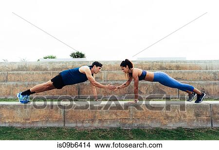 Picture - Man and woman exercising outdoors, doing push-ups on steps, South Point Park, Miami Beach, Florida, USA. Fotosearch