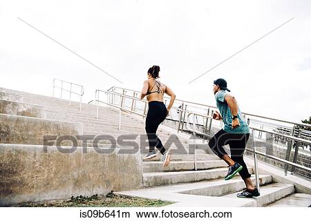 Picture - Man and woman exercising outdoors, running up steps, rear view, South Point Park, Miami Beach, Florida, USA. Fotosearch