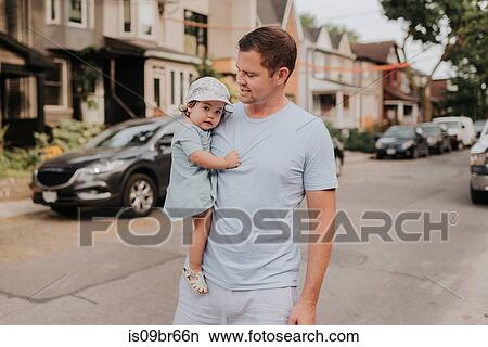 Man carrying daughter on street View Large Photo Image Picture - Man carrying daughter on street. Fotosearch