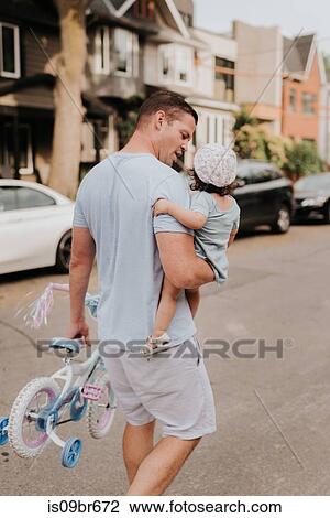 Man carrying daughter on street View Large Photo Image Stock Image - Man carrying daughter on street. Fotosearch