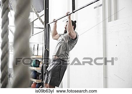 Man doing chin-up in cross training gym View Large Photo Image Stock Image - Man doing chin-up in cross training gym. Fotosearch