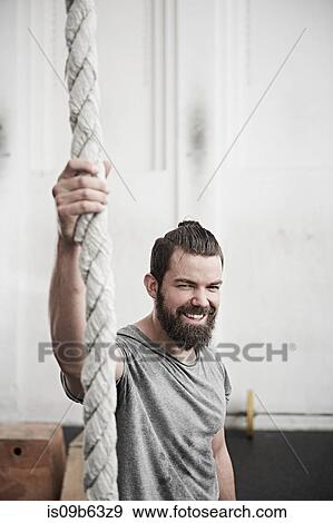 Man holding on to rope in cross training gym View Large Photo Image Stock Photo - Man holding on to rope in cross training gym. Fotosearch
