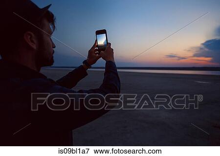 Man in hat taking photograph of sunset on beach, Odessa, Ukraine View Large Photo Image Stock Photo - Man in hat taking photograph of sunset on beach, Odessa, Ukraine. Fotosearch