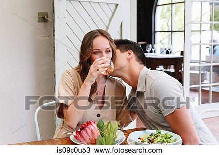 Man kissing woman on cheek in restaurant, Cape Town, South Africa View Large Photo Image Stock Image - Man kissing woman on cheek in restaurant, Cape Town, South Africa. Fotosearch