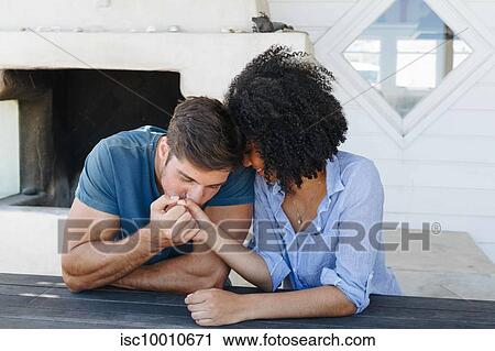 Man kissing woman's hand in beach house View Large Photo Image Stock Image - Man kissing woman's hand in beach house. Fotosearch