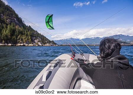 Man kite surfing on inflatable boat, Squamish, Canada View Large Photo Image Stock Image - Man kite surfing on inflatable boat, Squamish, Canada. Fotosearch