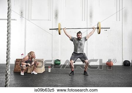 Man lifting barbell in cross training gym View Large Photo Image Stock Photography - Man lifting barbell in cross training gym. Fotosearch