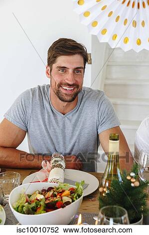 Man listening at dining table in home party View Large Photo Image Stock Image - Man listening at dining table in home party. Fotosearch