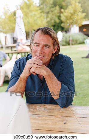 Man on garden bench listening to companion, Cape Town, South Africa View Large Photo Image Stock Photo - Man on garden bench listening to companion, Cape Town, South Africa. Fotosearch