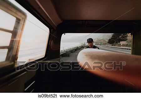 Man on van road trip loading surfboard, Ventura, California, US View Large Photo Image Stock Photograph - Man on van road trip loading surfboard, Ventura, California, US. Fotosearch