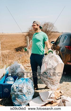 Man picking up rubbish by field, Georgetown, Canada View Large Photo Image Stock Image - Man picking up rubbish by field, Georgetown, Canada. Fotosearch