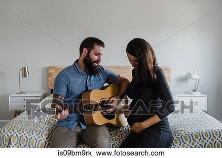 Man playing guitar to baby in wife's belly View Large Photo Image Stock Image - Man playing guitar to baby in wife's belly. Fotosearch