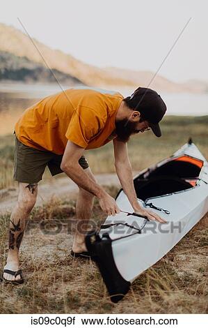 Stock Image - Man preparing kayak by lake, Kaweah, California, United States. Fotosearch