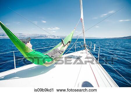 Man reclining in hammock aboard yacht near coast, Croatia View Large Photo Image Stock Image - Man reclining in hammock aboard yacht near coast, Croatia. Fotosearch