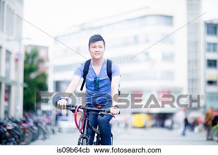 Stock Image - Man riding bicycle in city. Fotosearch