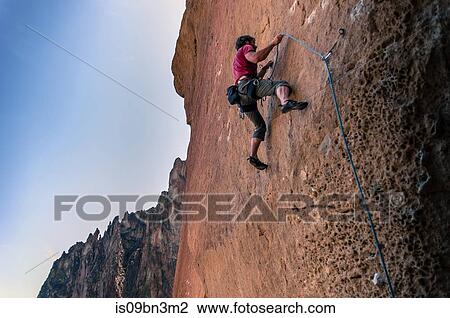 Stock Image - Man rock climbing, Smith Rock State Park, Oregon, USA. Fotosearch