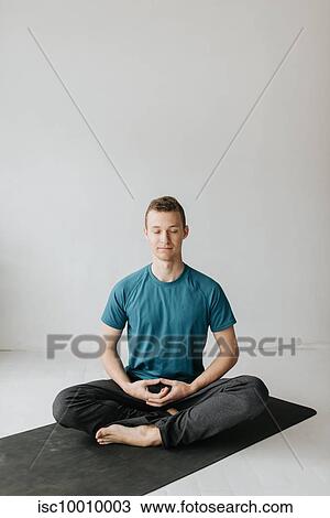 Man sitting in lotus pose in yoga studio View Large Photo Image Stock Image - Man sitting in lotus pose in yoga studio. Fotosearch