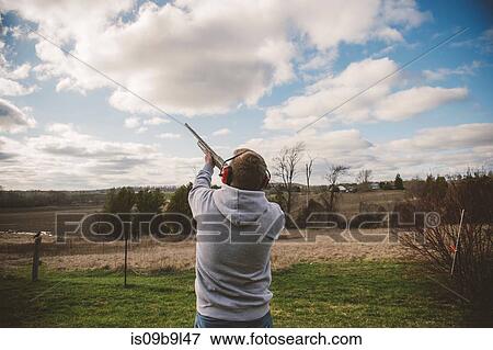 Man skeet shooting View Large Photo Image Stock Photo - Man skeet shooting. Fotosearch