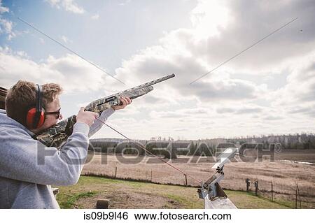 Man skeet shooting View Large Photo Image Stock Photograph - Man skeet shooting. Fotosearch