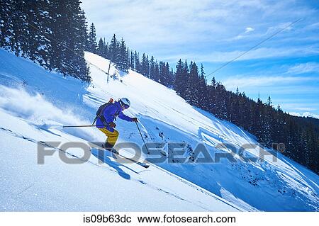 Man skiing down steep snow covered mountainside, Aspen, Colorado, USA View Large Photo Image Stock Image - Man skiing down steep snow covered mountainside, Aspen, Colorado, USA. Fotosearch