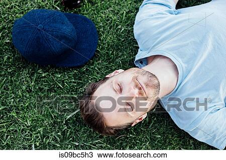 Stock Image - Man sleeping on grass. Fotosearch