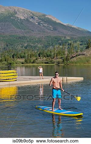 Man stand up paddleboarding on lake, Frisco, Colorado, USA View Large Photo Image Stock Photography - Man stand up paddleboarding on lake, Frisco, Colorado, USA. Fotosearch