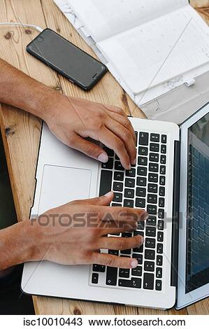Stock Image - Man typing on keypad of laptop. Fotosearch