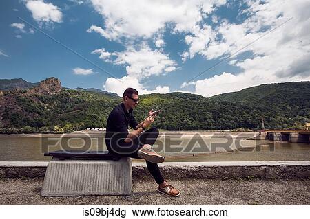 Man using mobile phone by beach, Draja, Vaslui, Romania View Large Photo Image Stock Image - Man using mobile phone by beach, Draja, Vaslui, Romania. Fotosearch