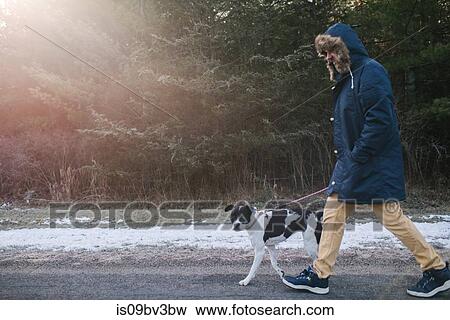 Stock Photo - Man walking dog in countryside. Fotosearch
