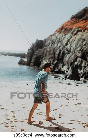 Picture - Man walking on beach, Big Sur, California, United States. Fotosearch
