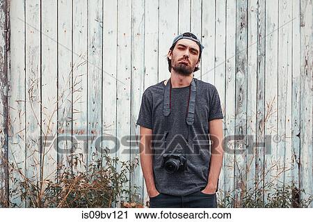Man with camera, wooden fence in background View Large Photo Image Stock Image - Man with camera, wooden fence in background. Fotosearch