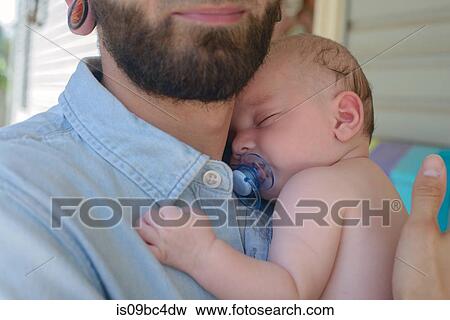 Stock Photo - Man with sleeping baby boy on shoulder. Fotosearch