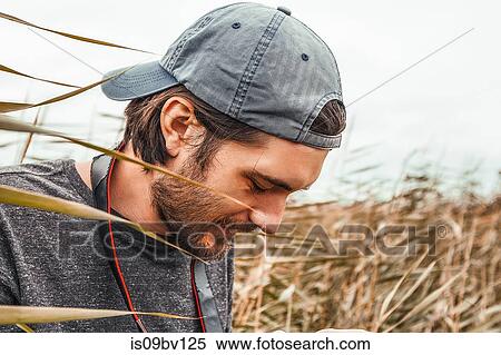 Stock Photography - Man with stubble wearing cap back to front. Fotosearch