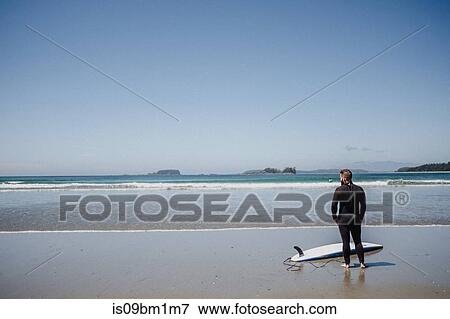 Man with surfboard on beach, Tofino, Canada View Large Photo Image Stock Photo - Man with surfboard on beach, Tofino, Canada. Fotosearch
