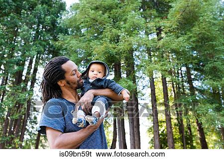 Mature man in forest carrying baby son in arms View Large Photo Image Stock Photograph - Mature man in forest carrying baby son in arms. Fotosearch