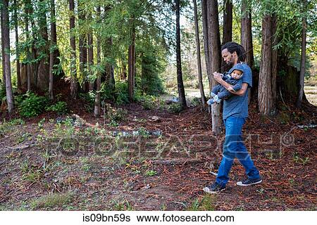 Mature man strolling in forest carrying baby son View Large Photo Image Stock Photograph - Mature man strolling in forest carrying baby son. Fotosearch