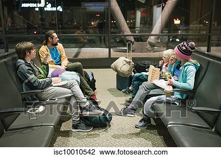 Mature man with sons and daughter waiting in airport departure lounge eating snacks View Large Photo Image Stock Image - Mature man with sons and daughter waiting in airport departure lounge eating snacks. Fotosearch