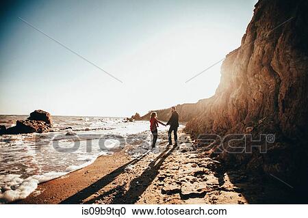 Mid adult couple holding hands on sunlit beach, Odessa Oblast, Ukraine View Large Photo Image Stock Image - Mid adult couple holding hands on sunlit beach, Odessa Oblast, Ukraine. Fotosearch