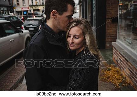 Mid adult couple hugging in street View Large Photo Image Picture - Mid adult couple hugging in street. Fotosearch