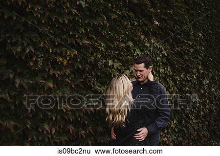 Stock Photograph - Mid adult couple, outdoors, hugging. Fotosearch