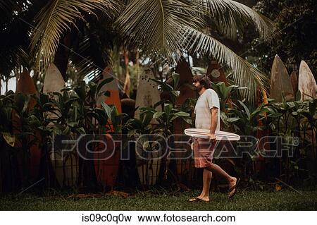 Mid adult male skateboarder carrying skateboard by old surfboard structure in park, Haiku, Hawaii, USA View Large Photo Image Stock Photo - Mid adult male skateboarder carrying skateboard by old surfboard structure in park, Haiku, Hawaii, USA. Fotosearch