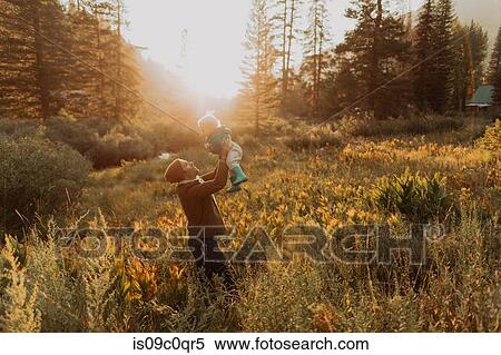 Mid adult man holding up toddler daughter in rural valley at sunset, Mineral King, California, USA View Large Photo Image Stock Photography - Mid adult man holding up toddler daughter in rural valley at sunset, Mineral King, California, USA. Fotosearch