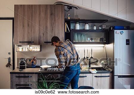 Mid adult man preparing food at kitchen hob, rear view View Large Photo Image Stock Image - Mid adult man preparing food at kitchen hob, rear view. Fotosearch