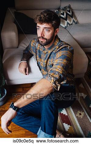 Mid adult man sitting on living room floor gazing View Large Photo Image Stock Photography - Mid adult man sitting on living room floor gazing. Fotosearch