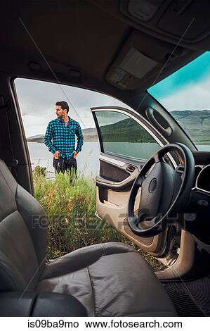 Mid adult man standing beside Dillon Reservoir, view through parked car, Silverthorne, Colorado, USA View Large Photo Image Picture - Mid adult man standing beside Dillon Reservoir, view through parked car, Silverthorne, Colorado, USA. Fotosearch