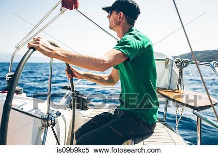Mid adult man steering yacht near coast, Croatia View Large Photo Image Stock Photography - Mid adult man steering yacht near coast, Croatia. Fotosearch