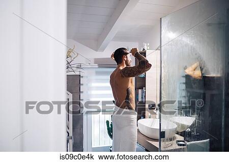 Mid adult man with tattoos combing hair at bathroom mirror View Large Photo Image Stock Image - Mid adult man with tattoos combing hair at bathroom mirror. Fotosearch