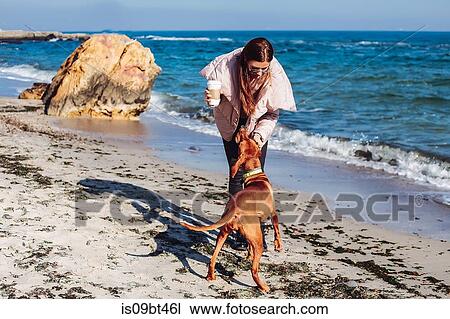Mid adult woman on beach petting her dog, Odessa, Odeska Oblast, Ukraine View Large Photo Image Stock Image - Mid adult woman on beach petting her dog, Odessa, Odeska Oblast, Ukraine. Fotosearch