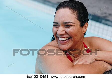 Mid adult woman with wet hair leaning on outdoor swimming poolside, looking over her shoulder, Cape Town, South Africa View Large Photo Image Stock Image - Mid adult woman with wet hair leaning on outdoor swimming poolside, looking over her shoulder, Cape Town, South Africa. Fotosearch